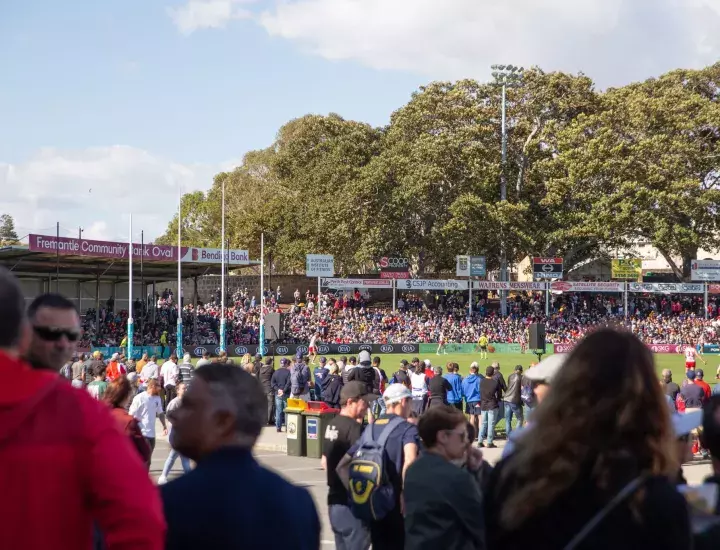 Fans watching a football game in a stadium. 
